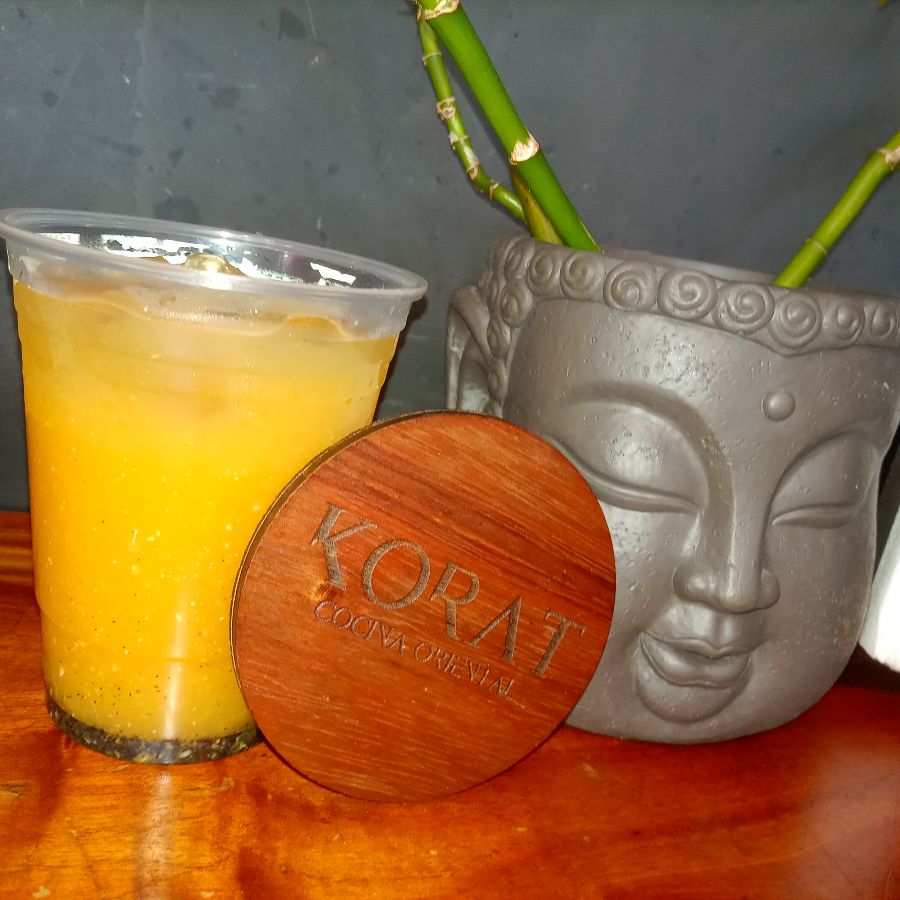 테이블 위에 놓인 음료 한 잔과 컵 받침. 컵 받침에는 코랏의 로고가 새겨져 있다.