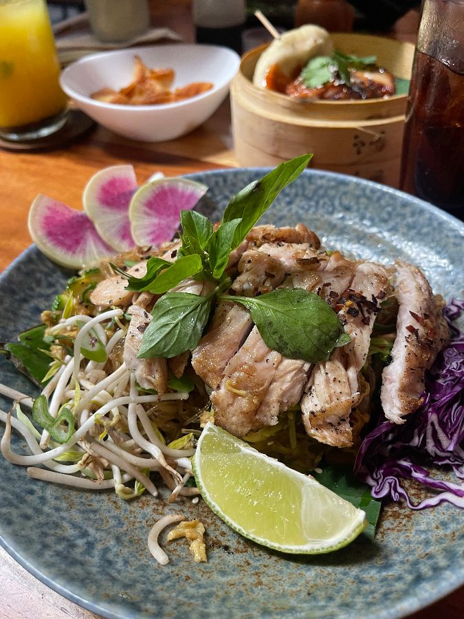 접시에 담긴 볶음 요리. 고기, 채소, 라임 등이 보인다.