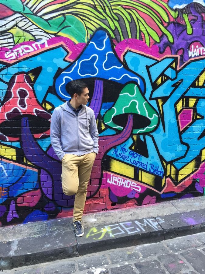 그래피티 벽 앞에서 포즈를 취한 손님