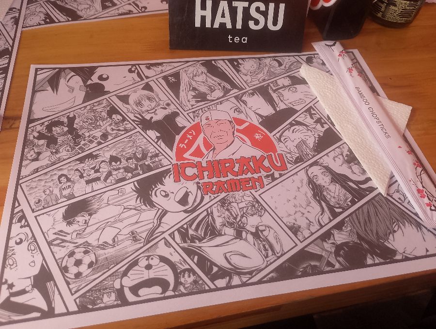 깔끔하게 세팅된 테이블 위 만화풍 매트와 젓가락