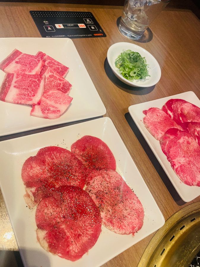 다양한 종류의 고기가 놓인 접시와 불판