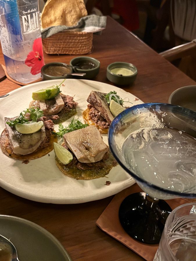 포르피리오스 칸쿤의 우아한 실내 전경. 고급스러운 조명과 세련된 테이블 세팅, 그리고 활기찬 분위기가 느껴진다.