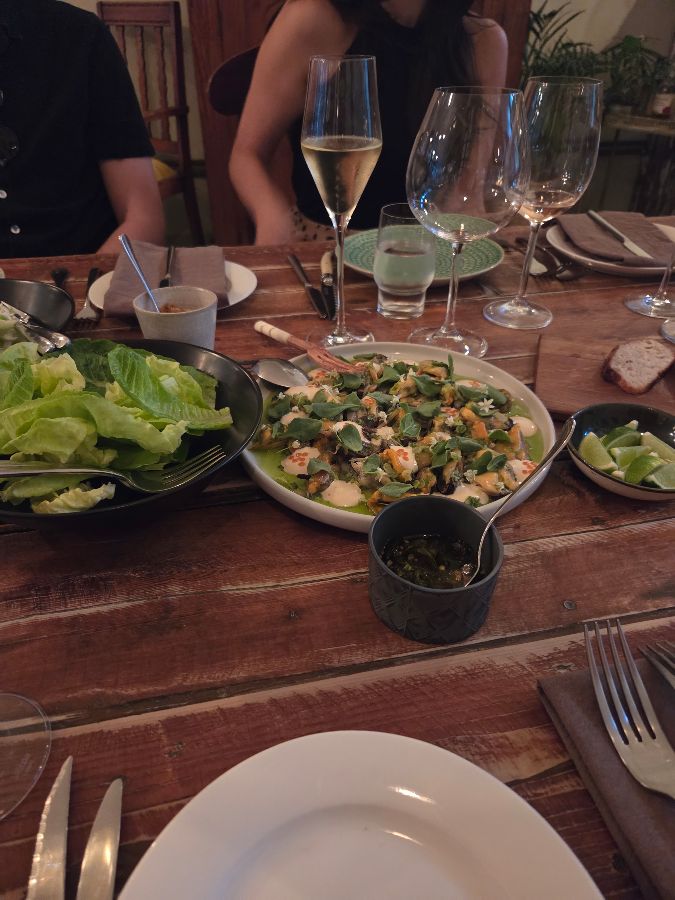 테이블 위에 놓인 음식 사진. 여러 개의 와인잔과 접시가 놓여 있다.