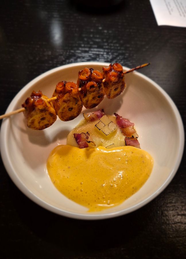 구운 문어 꼬치와 노란색 소스의 조화