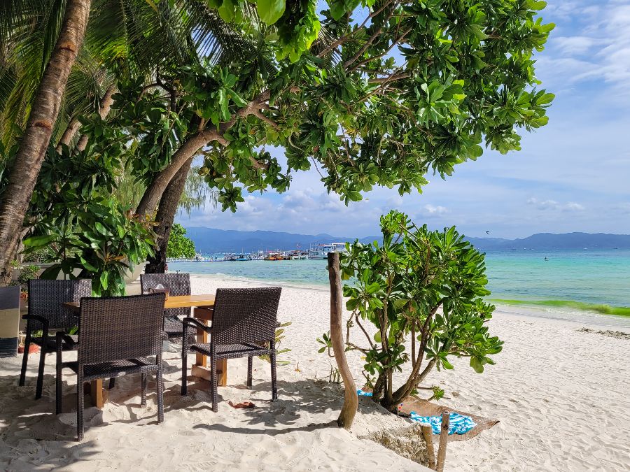 야자수 그늘 아래 해변 테이블