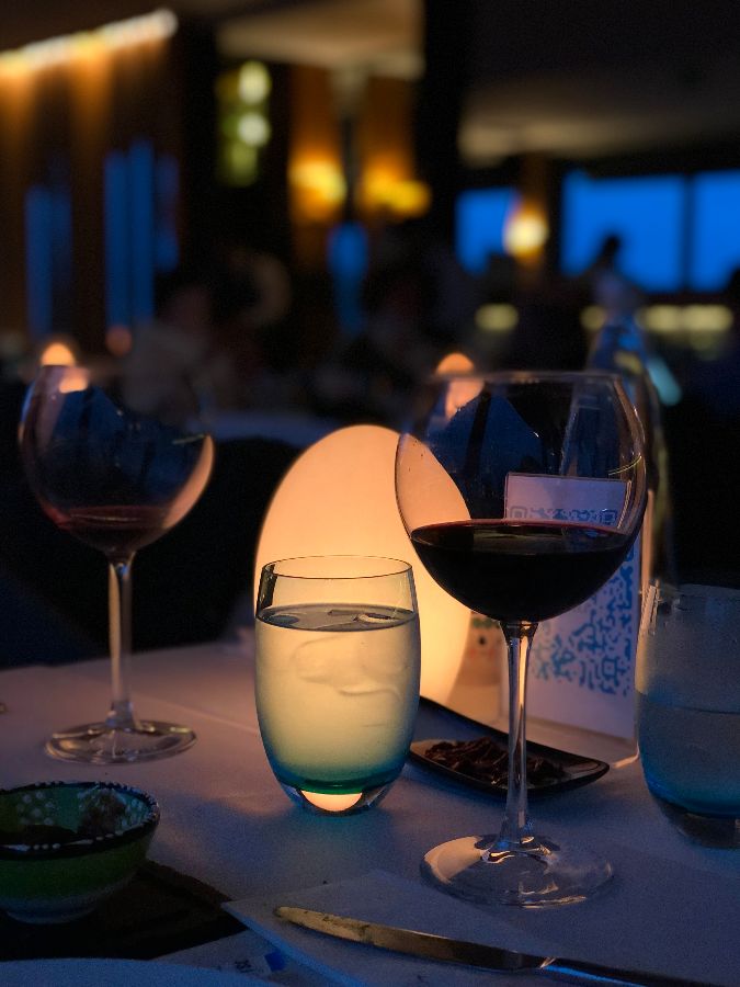 은은한 조명 아래 와인잔이 놓인 테이블