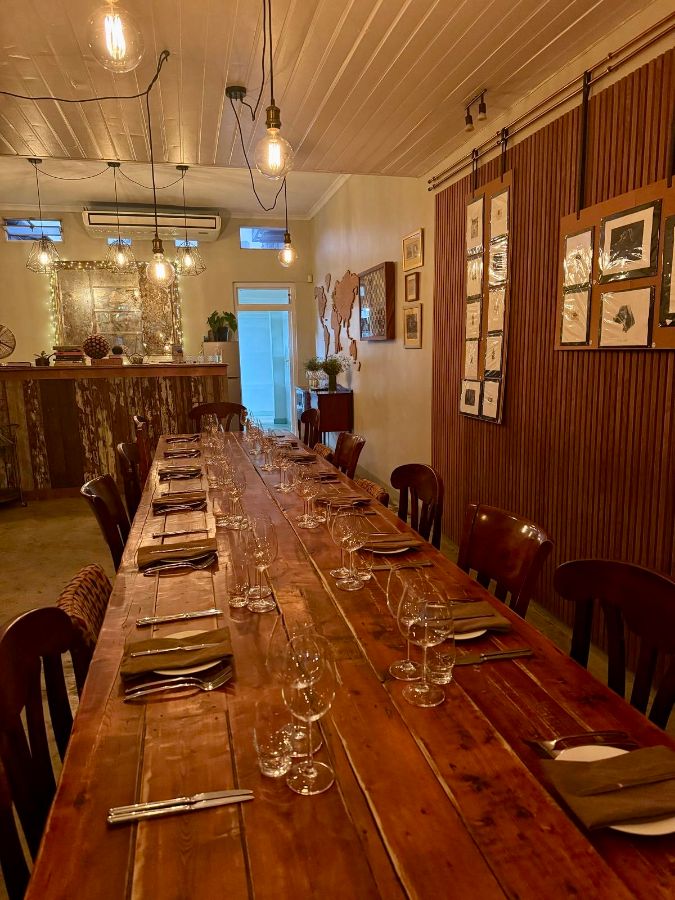 레스토랑 내부 모습. 길게 놓인 나무 테이블과 의자들이 보인다.