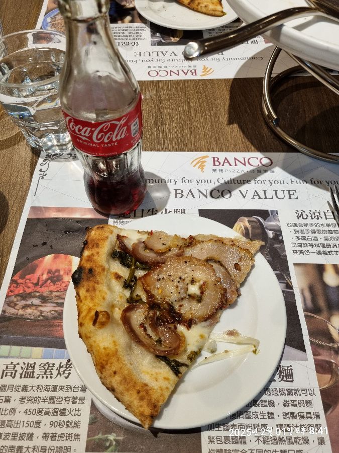 테이블 위에 놓인 피자 한 조각과 음료