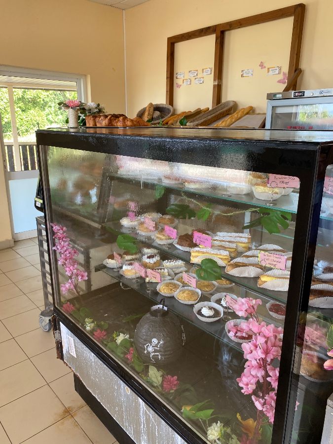 빵집 내부의 쇼케이스와 그 위에 놓인 갓 구운 빵들이 보이는 사진. 깔끔하게 정돈된 공간과 먹음직스러운 빵들이 따뜻한 분위기를 연출합니다.