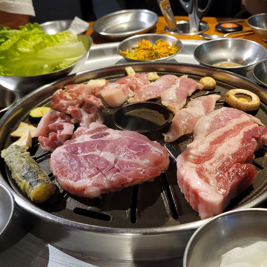 숯불 위에서 맛있게 익어가는 두툼한 삼겹살