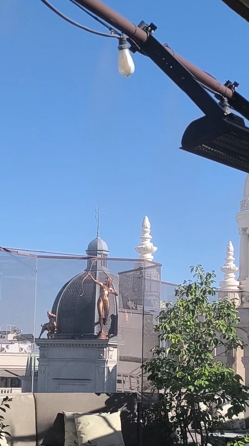 건물 꼭대기에 있는 조각상과 루프탑 풍경