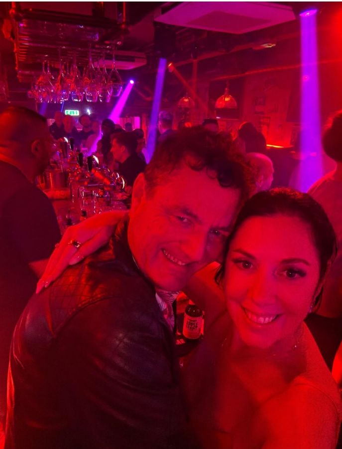 붉은 조명 아래 행복한 미소를 짓는 사람들