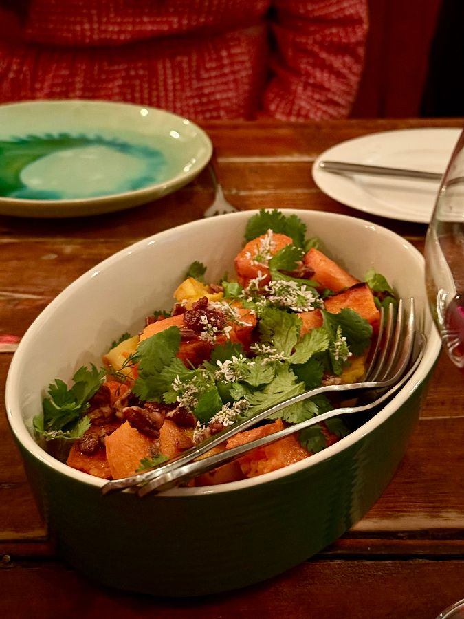 테이블 위에 놓인 음식 사진. 샐러드 요리가 담긴 그릇이 놓여 있다.