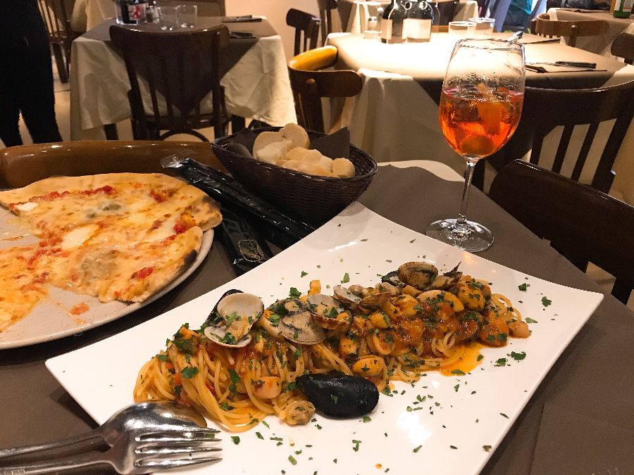 테이블 위에 놓인 피자와 파스타, 와인