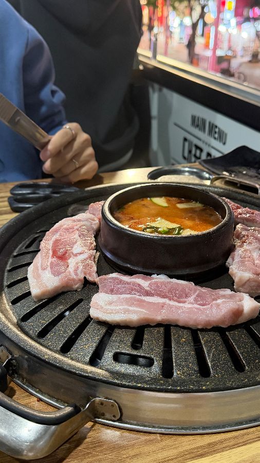 창밖 풍경과 불판 위의 삼겹살