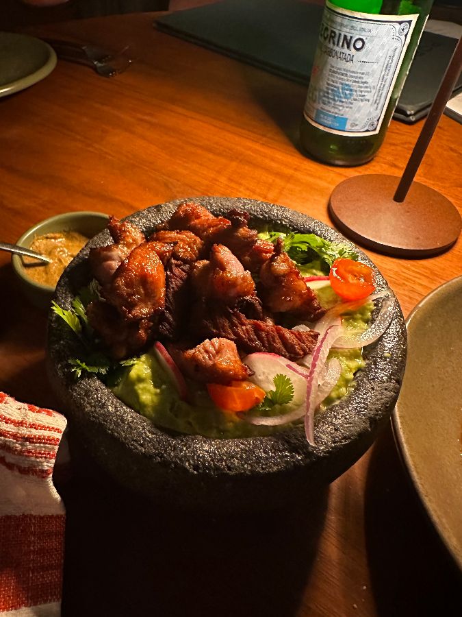 돌절구에 담긴 닭고기 요리. 튀긴 닭고기와 아보카도, 토마토, 양파 등이 다채롭게 어우러져 먹음직스러운 비주얼을 자랑한다.