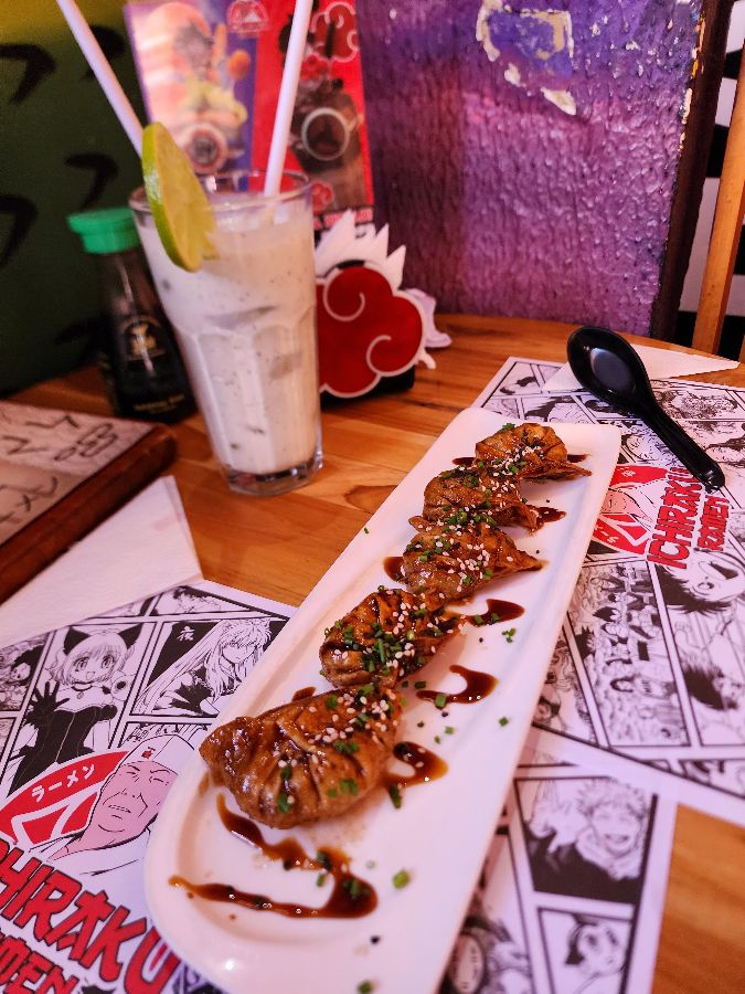 길쭉한 접시에 담긴 군만두와 라임이 꽂힌 음료