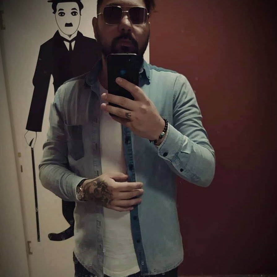 선글라스를 낀 남성이 거울 셀카를 찍고 있다.